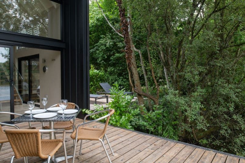 Alfresco dining on sun deck next to lake